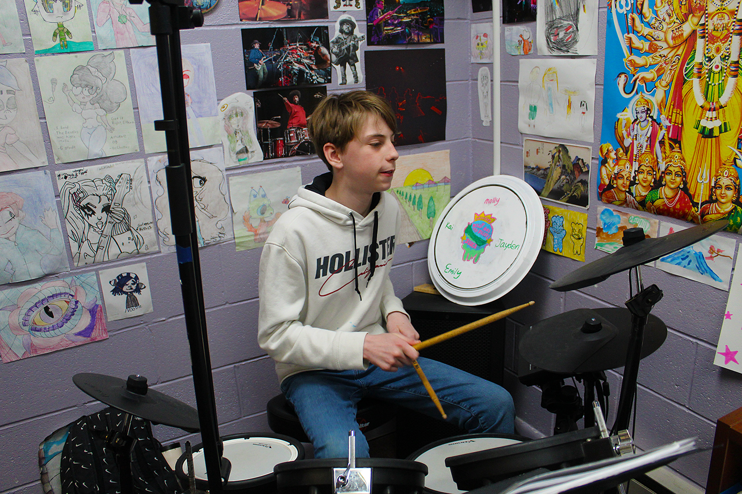 Male student playing drums in music class